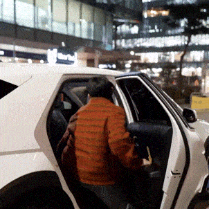 a man is getting out of a white car with the door open