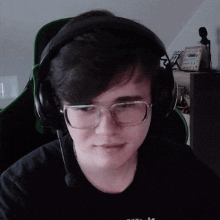 a young man wearing glasses and headphones is sitting in a green chair