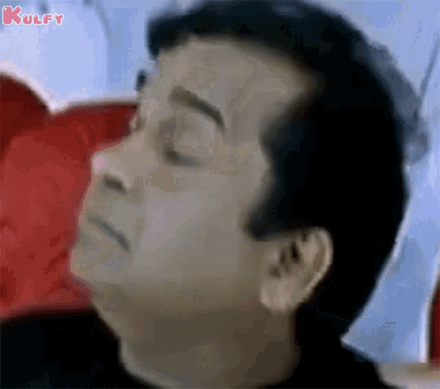 a close up of a man 's face with his eyes closed and the words kulfy on the bottom