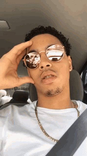 a man wearing sunglasses and a gold chain