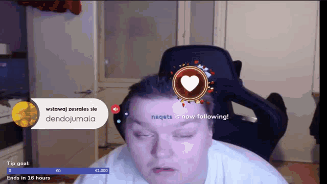 a man is sitting in a chair with a heart on his forehead and the words nagets is now following