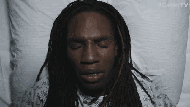 a man with dreadlocks is laying in a hospital bed with his eyes closed and #crypttv written on the bottom