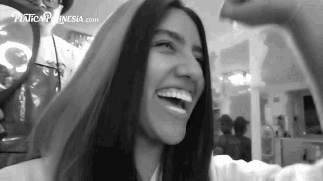 a black and white photo of a woman taking a selfie with a website in the background .