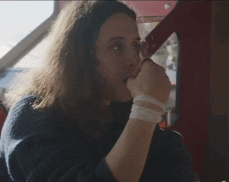 a woman with long hair is holding her hand to her mouth