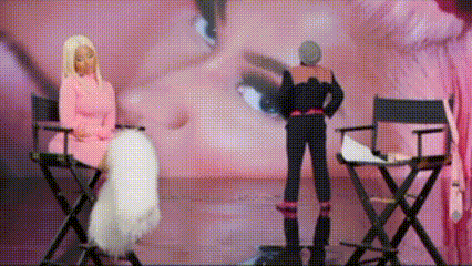 a woman in a pink dress sits in a directors chair