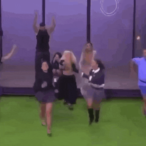 a woman in a skirt is dancing with another woman on a soccer field .