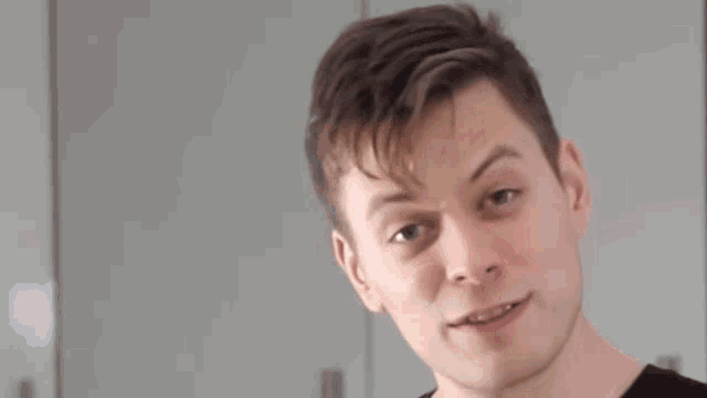 a man with braces on his teeth is making a funny face in front of a sign that says fuck