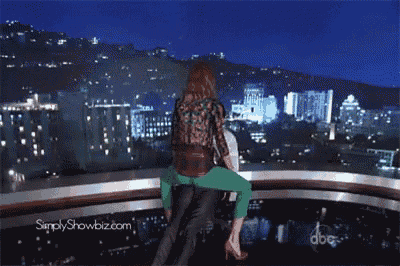 a woman is sitting on a man 's shoulders with simplyshowbiz.com written on the bottom