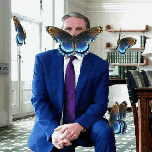 a man in a blue suit and purple tie with butterflies on his face