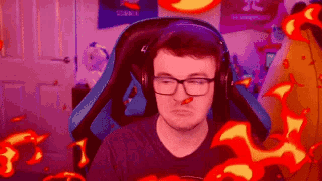 a man wearing glasses and headphones is sitting in a chair with a red pepper in his nose .