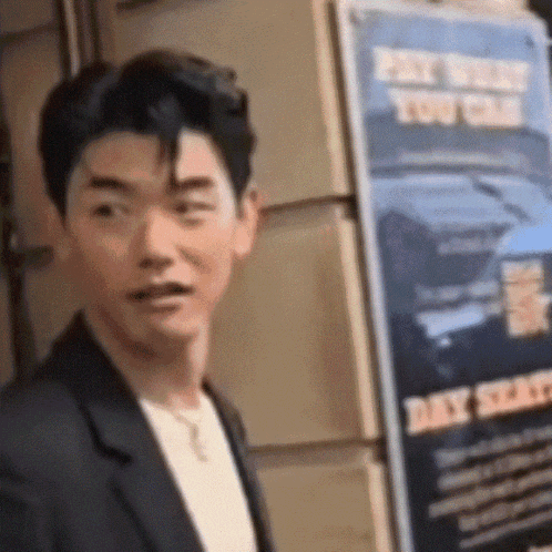 a man in a suit stands in front of a sign that says pay when you can