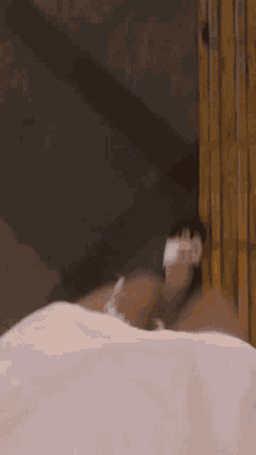 a person is laying in a bathtub with a white towel around their head .