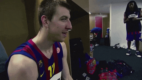 a man wearing a jersey with the number 17 on it stands in a locker room