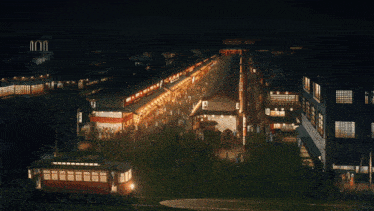 an aerial view of a city at night with a telephone booth in the middle of the street