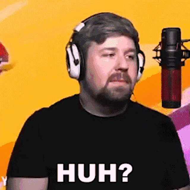a man with a beard wearing headphones and a microphone .