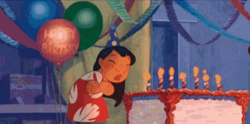 a woman is blowing out candles on a birthday cake .