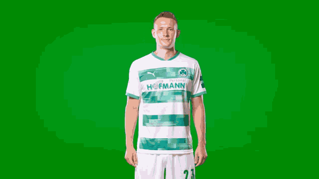a man wearing a green and white hofmann jersey stands in front of a green screen