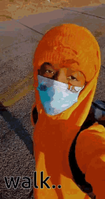 a person wearing an orange hoodie and a mask says walk ..