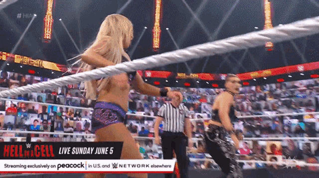 two women are wrestling in a wrestling ring with a sign that says hell in a cell live sunday june 5