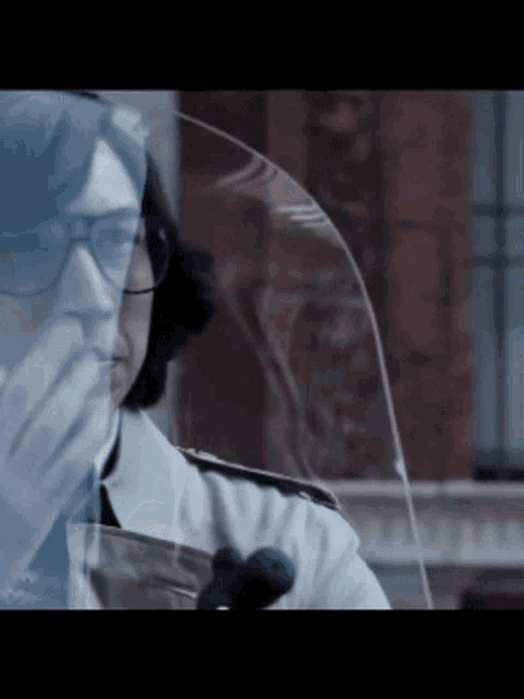 a man wearing glasses is sitting on a motorcycle with a windshield