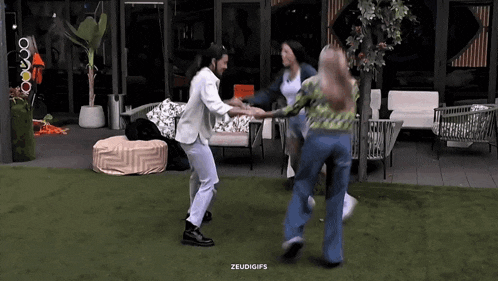 a man and two women are dancing on a patio .