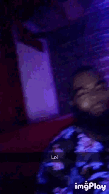 a blurry picture of a man in a dark room with purple lights and the words lol on the bottom right