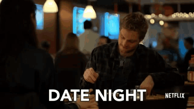 a man is sitting at a table with a woman and the words date night written on the screen