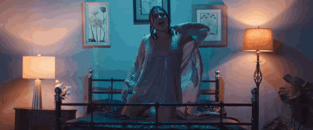 a woman is kneeling on a bed in a bedroom