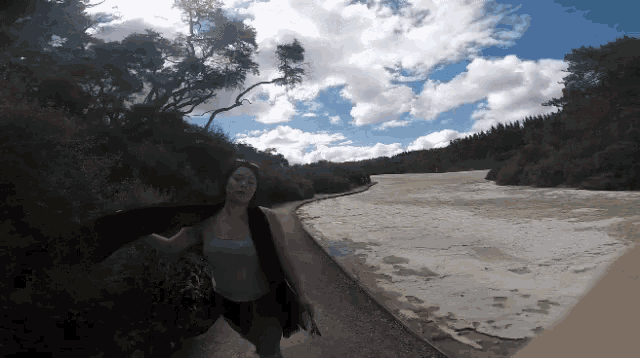a woman in a black jacket is walking down a path