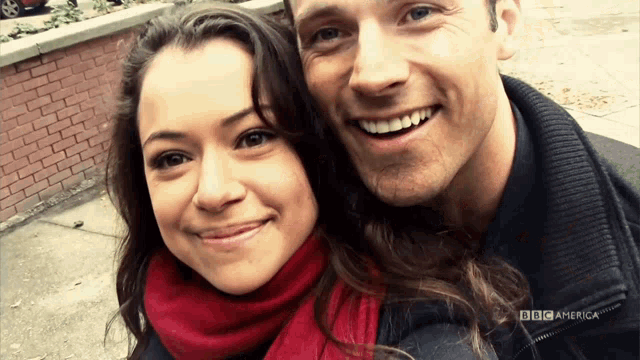 a man and a woman are posing for a picture with the bbc america logo behind them
