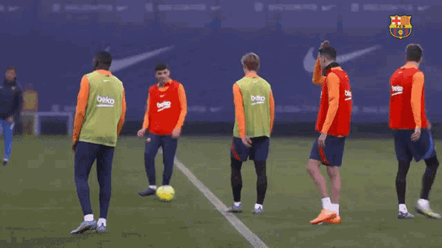 a group of soccer players wearing beko vests are on a field