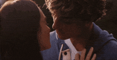a man and a woman kissing with the sun shining through their hair