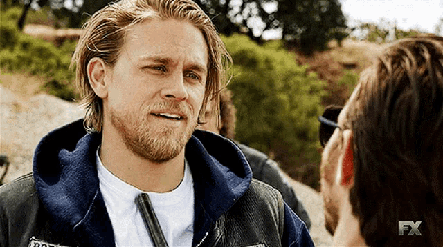 a man with a beard is wearing a jacket that says fx