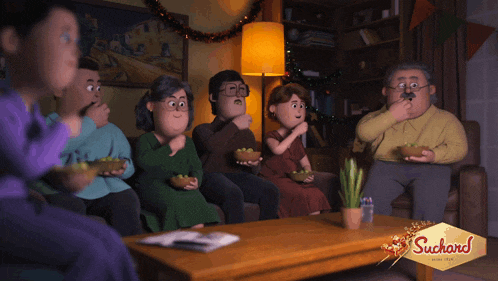 a group of people are sitting around a table with suchard written on it