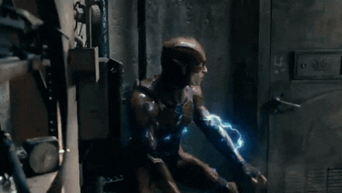 a man in a superhero costume is being struck by lightning in a room .