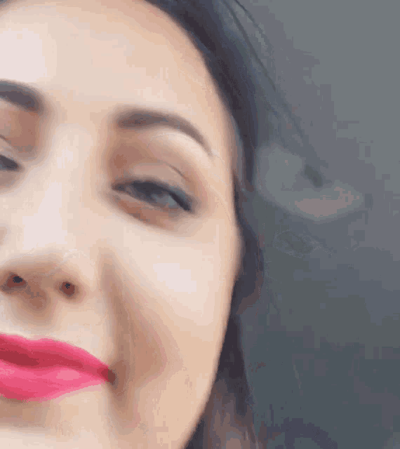 a close up of a woman 's face with pink lipstick