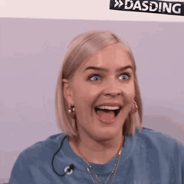 a woman with a surprised look on her face is wearing a blue shirt
