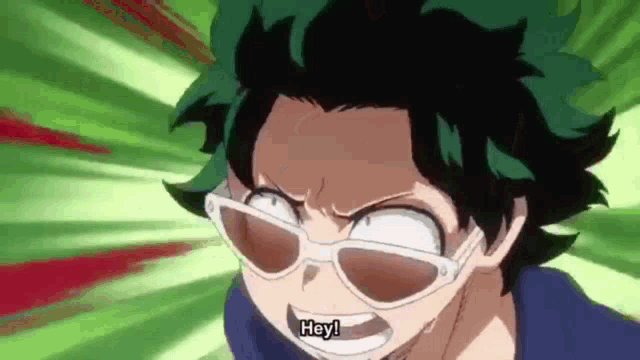 a close up of a person wearing sunglasses and saying hey !