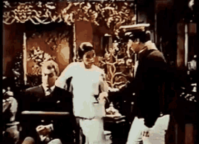 a man and a woman are standing in a room talking to each other .