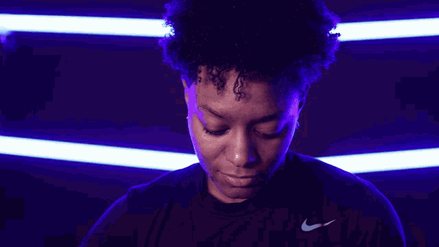 a woman in a black nike shirt looks down