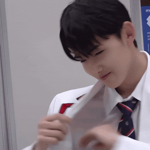 a man wearing a white shirt and tie looks down