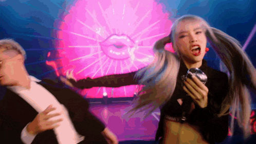 a man and woman are dancing in front of a ferris wheel .