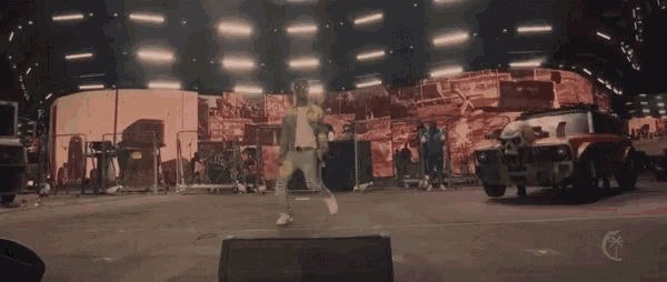 a man stands on a stage in front of a large screen that says ' fast and furious '