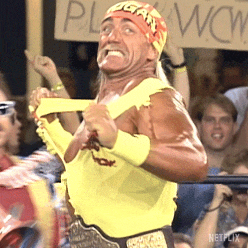 a man in a yellow wrestling outfit is holding a sign that says wow