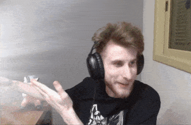 a man wearing headphones and a black shirt that says ' a ' on it