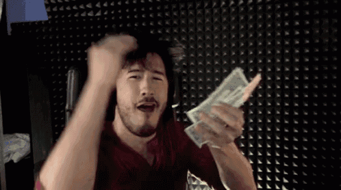 a man with a beard is holding a stack of money and making a funny face .