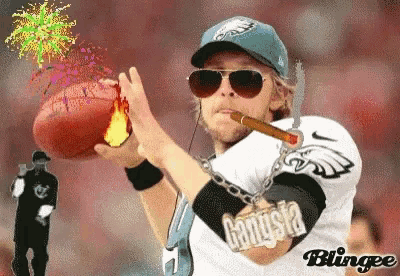 a man in a eagles jersey is holding a football and smoking a cigar