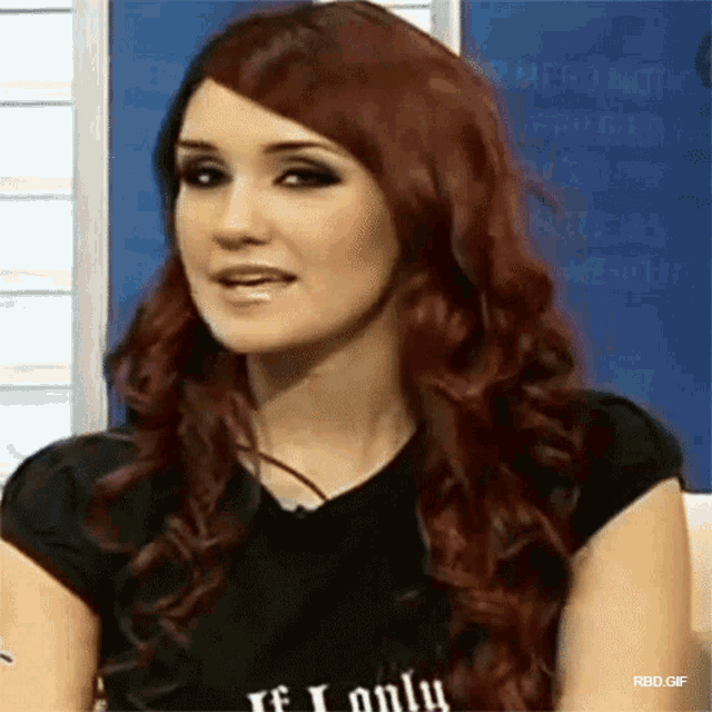 a woman with red hair is wearing a black shirt that says " if i only "