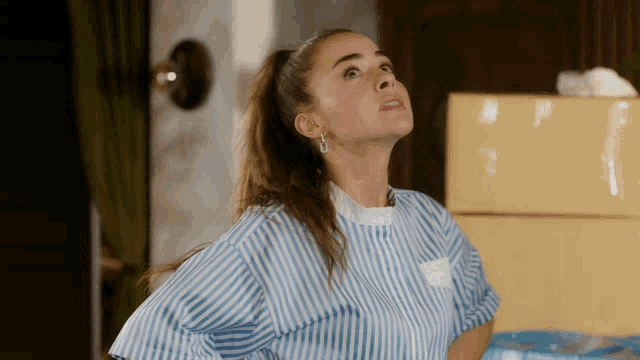 a woman wearing a blue and white striped shirt has a name tag on her back