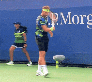 a man holding a tennis racquet in front of a wall that says p.morg